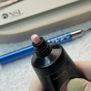 NSI Polypaste pink poly gel hybrid nail product shown dispensing from tube for sculpting and extensions